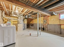 Unfinished basement with concrete flooring and exposed ceiling joists - 