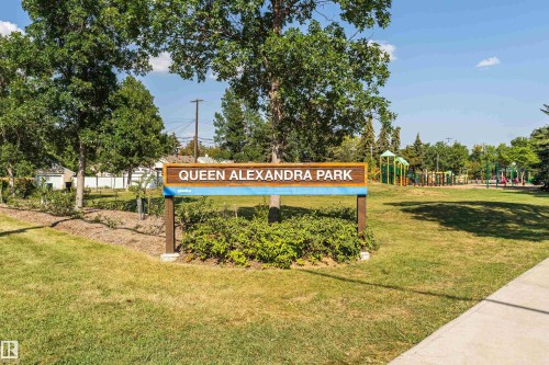 Park entrance featuring a wooden park sign, green space, and mature trees - 211 10808 71 Avenue, Edmonton, AB 
