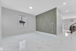 Spacious room featuring white porcelain tile flooring with subtle veining, recessed ceiling lighting, a decorative accent wall with geometric paneling, and a window with horizontal blinds - 