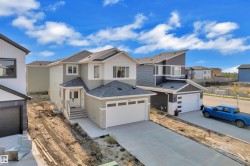 Contemporary two-story residence featuring light green siding and white trim accents - 