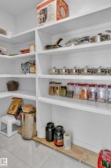 Built-in pantry shelving featuring white finishes and light tile flooring - 
