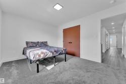 Bedroom featuring plush gray carpeting and a contemporary ceiling light fixture - 