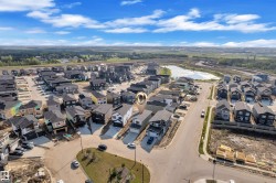 Newly constructed residential community featuring contemporary homes, paved streets, and a central stormwater pond - 