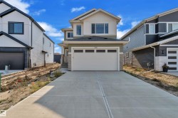 Contemporary two-story residence featuring a combination of light green siding, white trim, and stone accents - 
