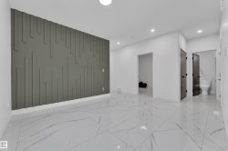 Accent wall with vertical paneling, recessed lighting, white tile flooring with veining, white baseboards, and dark wood-finish doors - 