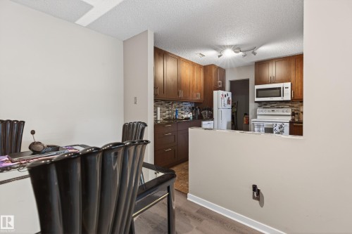 Kitchen featuring wood cabinetry, stainless steel appliances, and a tiled backsplash - 35 3111 142 Avenue, Edmonton, AB 