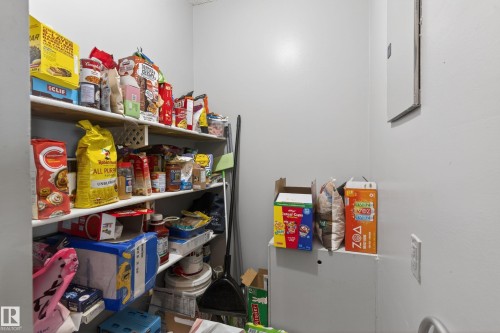 Utility closet with multiple levels of built-in shelving, painted walls, and an electrical outlet - 35 3111 142 Avenue, Edmonton, AB 