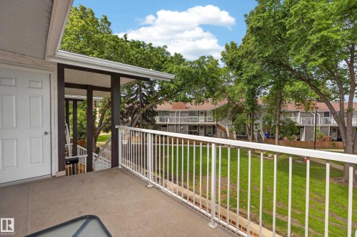 Concrete patio featuring white railing and a white paneled door - 35 3111 142 Avenue, Edmonton, AB 