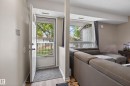Entryway featuring a white door with a storm door, wood-finish flooring, and a neutral wall color - 35 3111 142 Avenue, Edmonton, AB 