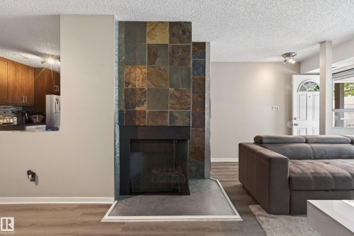 Statement fireplace featuring stacked slate tile surround and hearth - 35 3111 142 Avenue, Edmonton, AB 