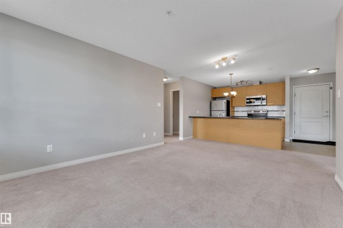 Open-concept living space featuring light gray walls and plush carpet flooring - 3302 9351 Simpson Drive, Edmonton, AB 