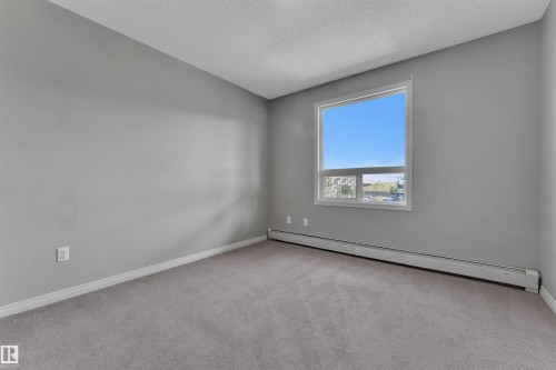 Carpeted room featuring a single window and baseboard heating - 3302 9351 Simpson Drive, Edmonton, AB 