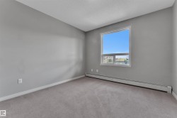 Carpeted room featuring a single window and baseboard heating - 