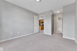 Carpeted room with light gray wall paint and white trim, featuring a flush mount ceiling light - 