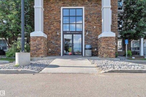 Building exterior featuring stacked stone cladding with white column accents - 3302 9351 Simpson Drive, Edmonton, AB 