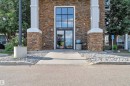 Building exterior featuring stacked stone cladding with white column accents - 3302 9351 Simpson Drive, Edmonton, AB 