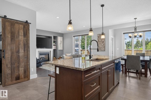 Central kitchen island with a granite countertop and undermount sink - 14016 161 Avenue, Edmonton, AB 