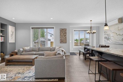 Open-concept living space featuring recessed lighting, a built-in shelving unit, and multiple large windows - 14016 161 Avenue, Edmonton, AB 