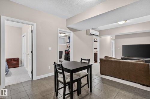 Open-concept living space featuring a tiled floor, recessed lighting, and a wall-mounted mini-split system - 14016 161 Avenue, Edmonton, AB 