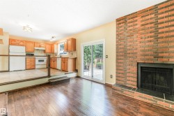 Sunken living room with brick fireplace and sliding patio door to backyard. - 