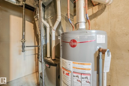 Mechanical room featuring a high efficiency furnace and newer hot water tank - 2921 130 Avenue, Edmonton, AB 