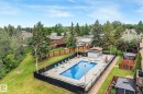 Fenced outdoor swimming pool with surrounding concrete patio - 2921 130 Avenue, Edmonton, AB 