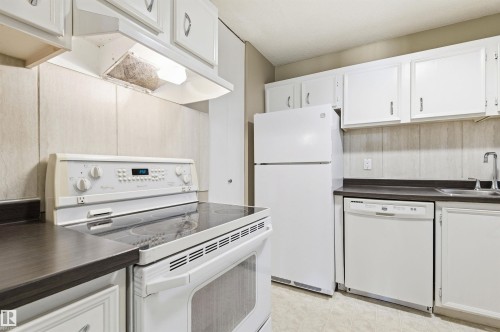 Kitchen featuring white cabinetry, dark countertops, a built-in range, a refrigerator, and a dishwasher - 2005 Saddleback Road, Edmonton, AB - Indoor Photo Showing Kitchen