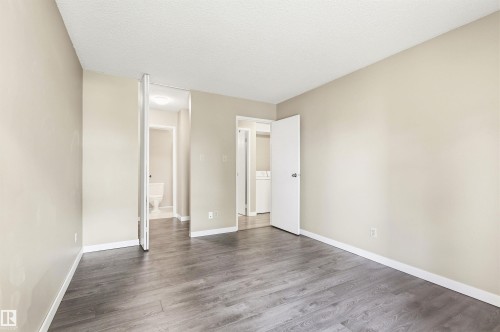 Spacious room featuring wood-finish flooring, neutral-toned walls, and white baseboards - 2005 Saddleback Road, Edmonton, AB - Indoor Photo Showing Other Room