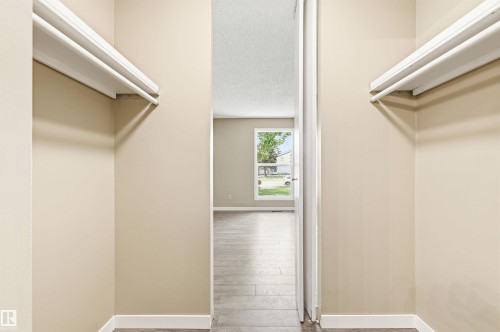 Walk-through closet featuring dual hanging rods and shelving - 2005 Saddleback Road, Edmonton, AB - Indoor With Storage