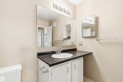 Vanity with a white oval sink, dark countertop, and brushed nickel faucet - 