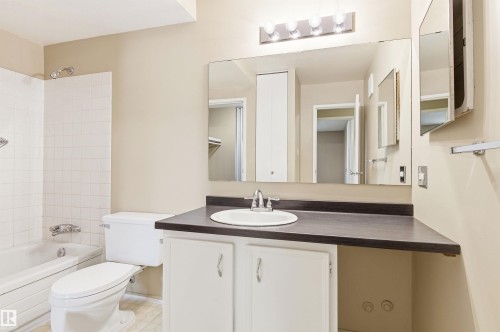 Bathroom vanity with an integrated sink, dark countertop, and white cabinetry - 2005 Saddleback Road, Edmonton, AB - Indoor Photo Showing Bathroom