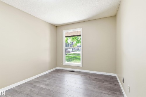 Neutral tone wall finish with white trim, wood-finish flooring, and a window with white casing - 2005 Saddleback Road, Edmonton, AB - Indoor Photo Showing Other Room