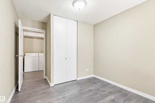 Room featuring wood-finish flooring, neutral wall tones, and a built-in closet with bifold doors - 2005 Saddleback Road, Edmonton, AB - Indoor