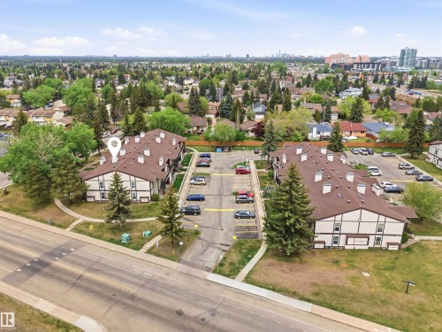 Multi-unit residential complex with a brown shingle roof and white siding with brown trim - 2005 Saddleback Road, Edmonton, AB - Outdoor With View