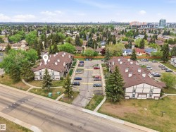 Multi-unit residential complex with a brown shingle roof and white siding with brown trim - 