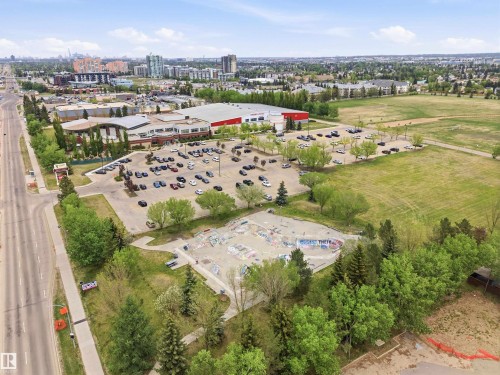 Aerial perspective showcasing a large commercial structure with an expansive parking area, surrounded by green spaces and mature trees - 2005 Saddleback Road, Edmonton, AB - Outdoor With View
