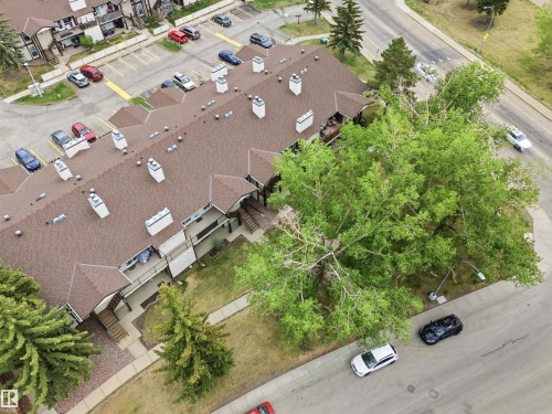 Multi-unit residential structure featuring a brown shingle roof, multiple chimneys, and private balconies with wood railings - 2005 Saddleback Road, Edmonton, AB -  With View