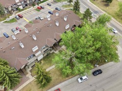 Multi-unit residential structure featuring a brown shingle roof, multiple chimneys, and private balconies with wood railings - 
