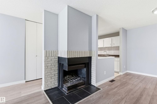 Fireplace featuring a light brick surround and black hearth - 2005 Saddleback Road, Edmonton, AB - Indoor With Fireplace
