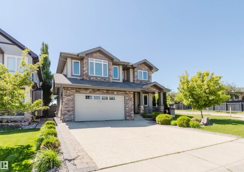 Two-story residence featuring a stone and siding facade, a two-car garage, and a concrete driveway - 4377 Mcclung Crescent, Edmonton, AB 