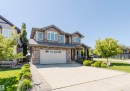 Two-story residence featuring a stone and siding facade, a two-car garage, and a concrete driveway - 4377 Mcclung Crescent, Edmonton, AB 