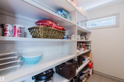 White built-in shelving system providing extensive storage, complemented by a horizontal window providing natural light - 