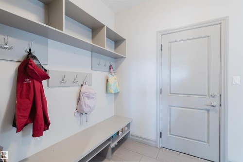 Built-in mudroom organization system featuring a storage bench with open shelving, wall-mounted coat hooks, and overhead cubbies - 4377 Mcclung Crescent, Edmonton, AB 