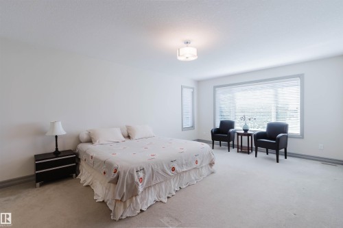 Bright room featuring neutral carpeting, a large window with white blinds, and a circular ceiling light fixture - 4377 Mcclung Crescent, Edmonton, AB 