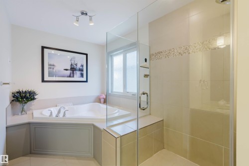 Bathroom featuring a built-in jetted tub, a frameless glass shower enclosure, a shower bench, and a privacy window - 4377 Mcclung Crescent, Edmonton, AB 