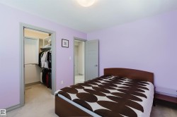 Bedroom featuring light purple walls and neutral carpet flooring - 