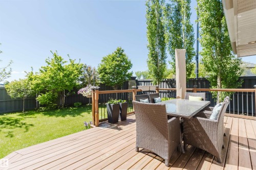 Expansive wood-finish deck with a wood railing and black balusters - 4377 Mcclung Crescent, Edmonton, AB 