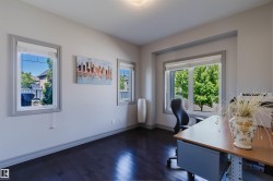 Bright room featuring dark wood-finish flooring and multiple windows with grey trim - 