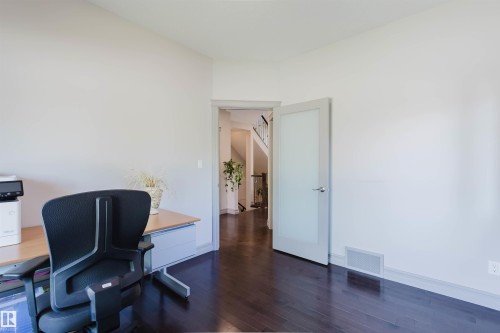 Interior room featuring dark wood-finish flooring and light-toned walls - 4377 Mcclung Crescent, Edmonton, AB 
