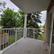 Private balcony featuring durable composite flooring and white metal railings - 
